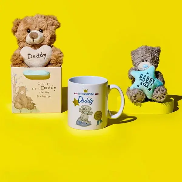 Father’s Day gifts on a yellow background featuring two teddy bears, a Daddy mug, and a keepsake box labelled cuddles from daddy favourite